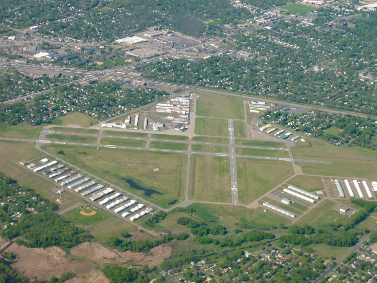 Aerial view of Crystal Airport runways and hangars surrounded by tree-lined residential blocks
