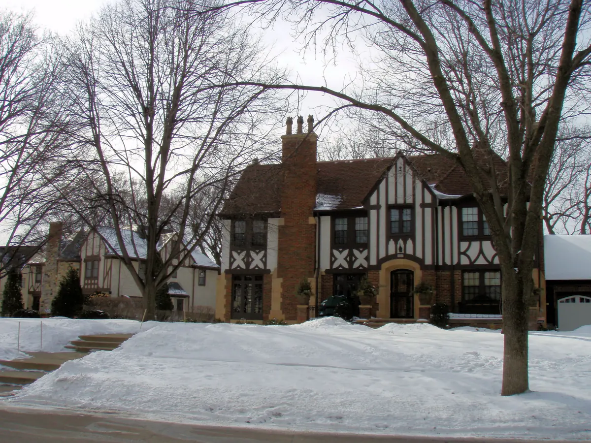 Half-timbered Tudor Revival houses with brick chimneys and snow-covered lawns in Edina's Country Club district