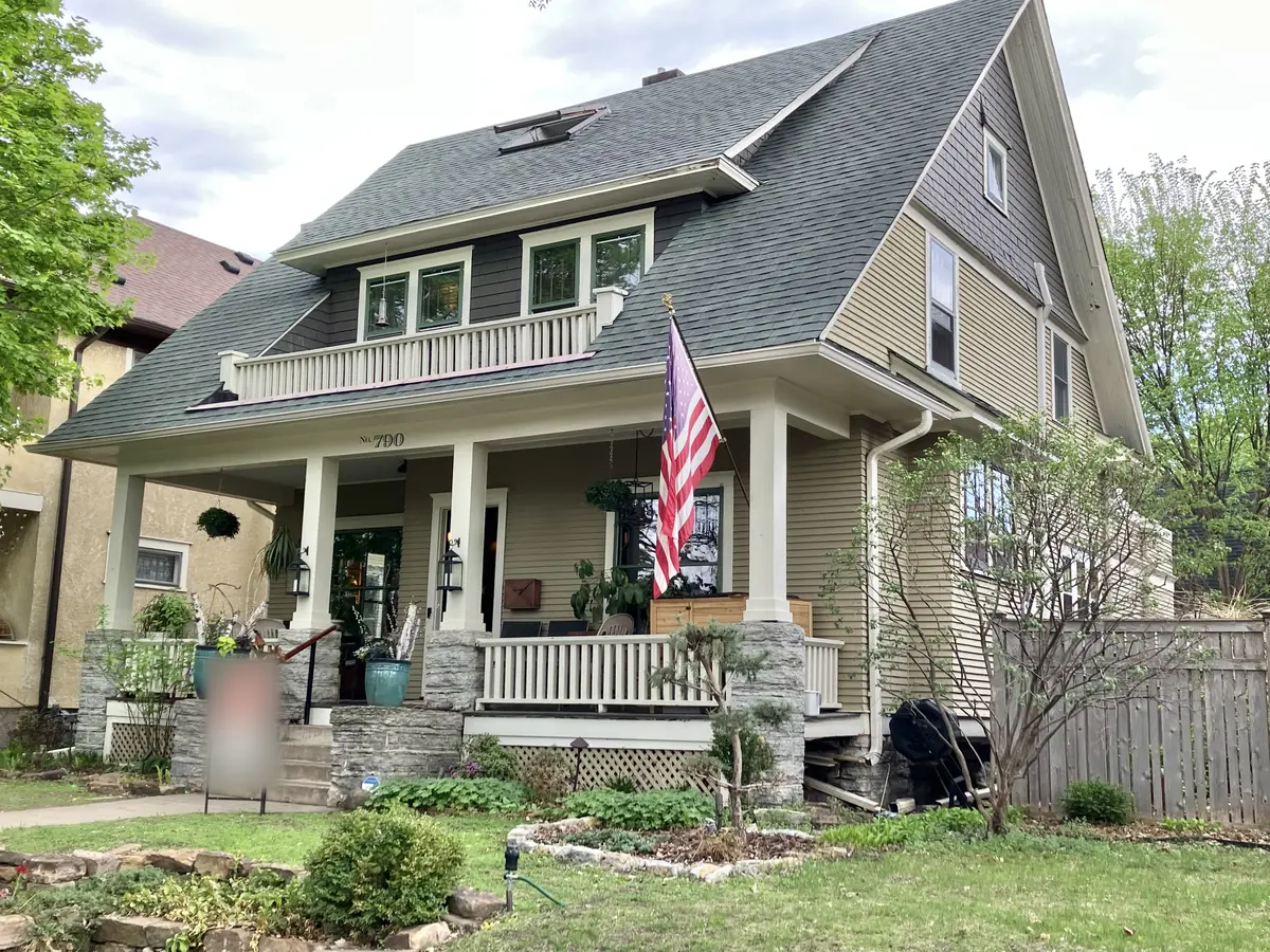 Two-and-a-half-story Craftsman house with a deep front porch, stone piers and a shed dormer balcony on Ashland Avenue in St. Paul
