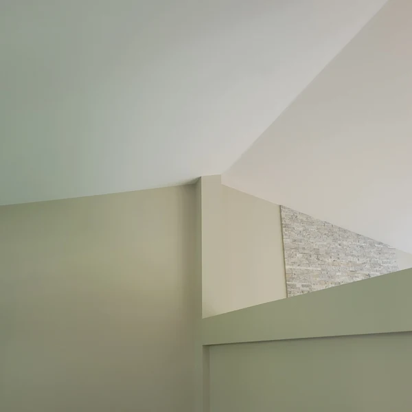 Finished smooth ceiling and walls beside a stone accent wall
