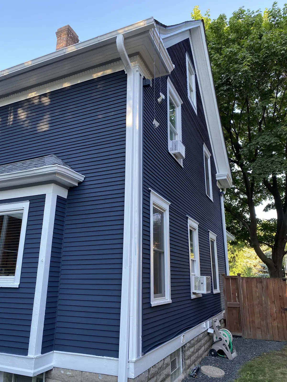 Side after: Exterior repaint (navy with white porch) · Minneapolis.